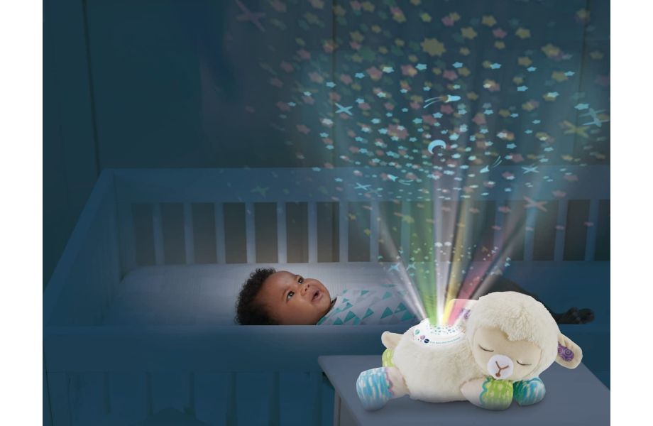 3-in-1 Starry Skies Sheep Soother with boy in cot enjoying the projector