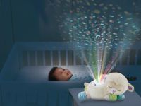 3-in-1 Starry Skies Sheep Soother with boy in cot enjoying the projector
